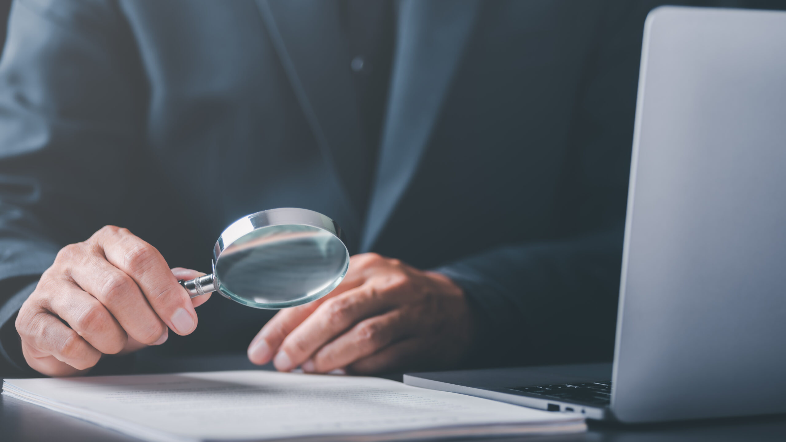 Businessman holding a magnifying glass,Audit Document Concepts,